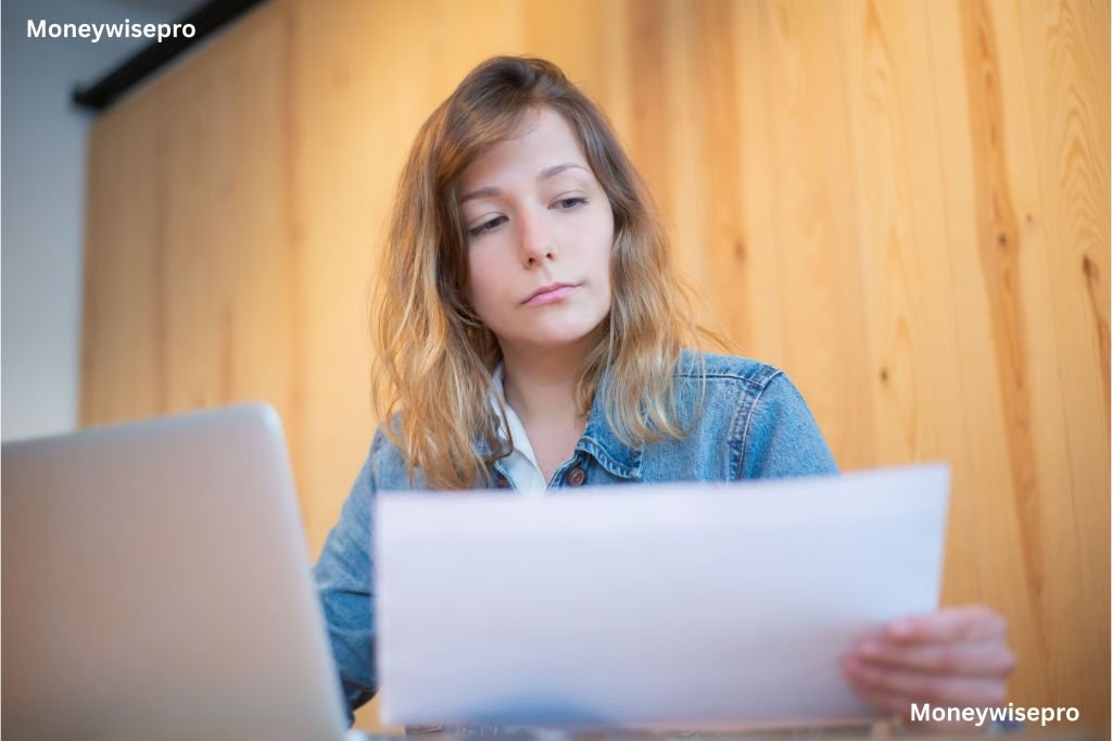  A woman reviewing car loan paperwork spread out on a dining table