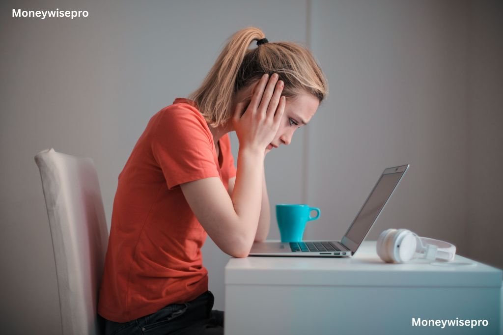 person sitting at a table reviewing bills with a calculator and laptop