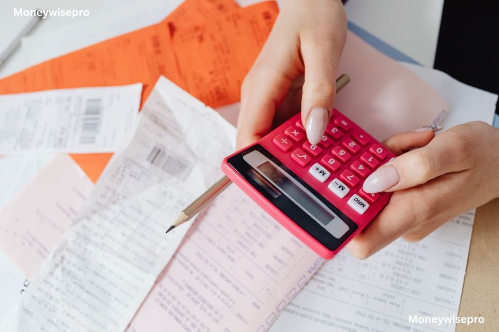 Close-up of a hand holding cash bills while pressing keys on a calculator