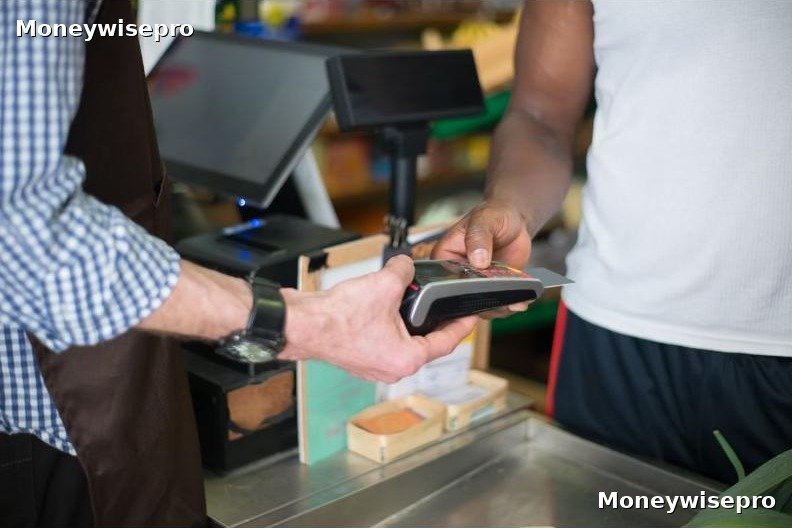 A small business owner standing behind a checkout counter reviewing daily sales