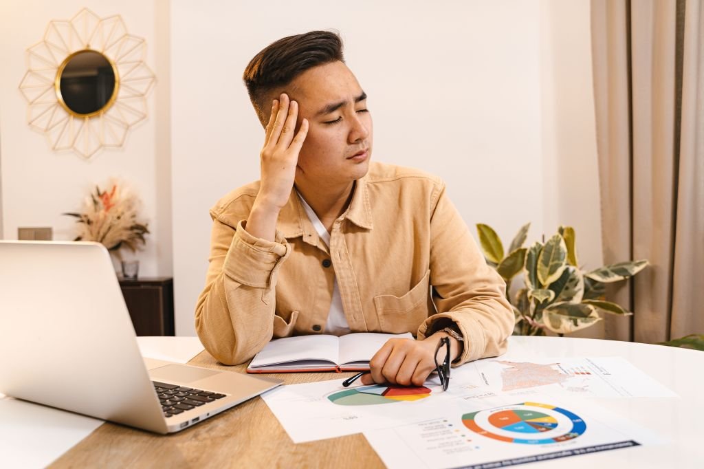 Person looking at apartment listings online with frustrated, defeated expression