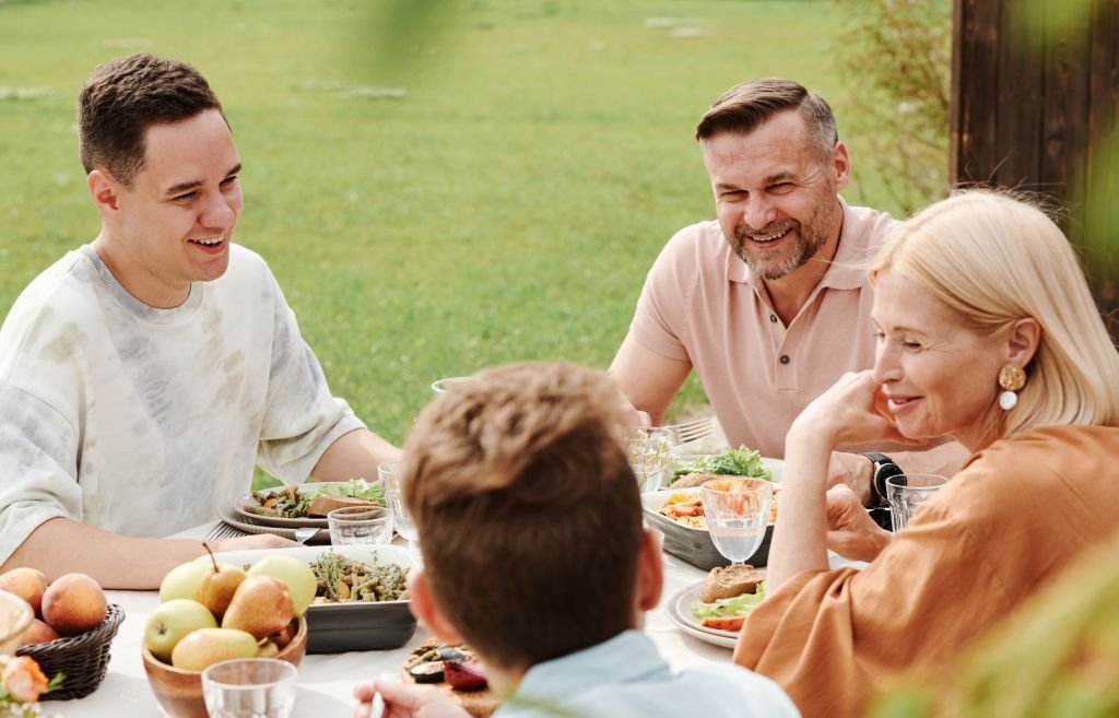  happy family sitting together at dinner table