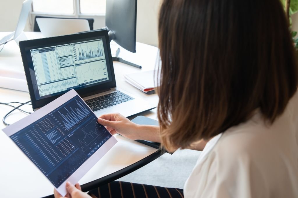 Person sitting at a laptop reviewing their bank and credit card statements