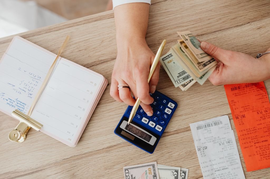 Calculator and bills on a kitchen table representing budgeting and debt