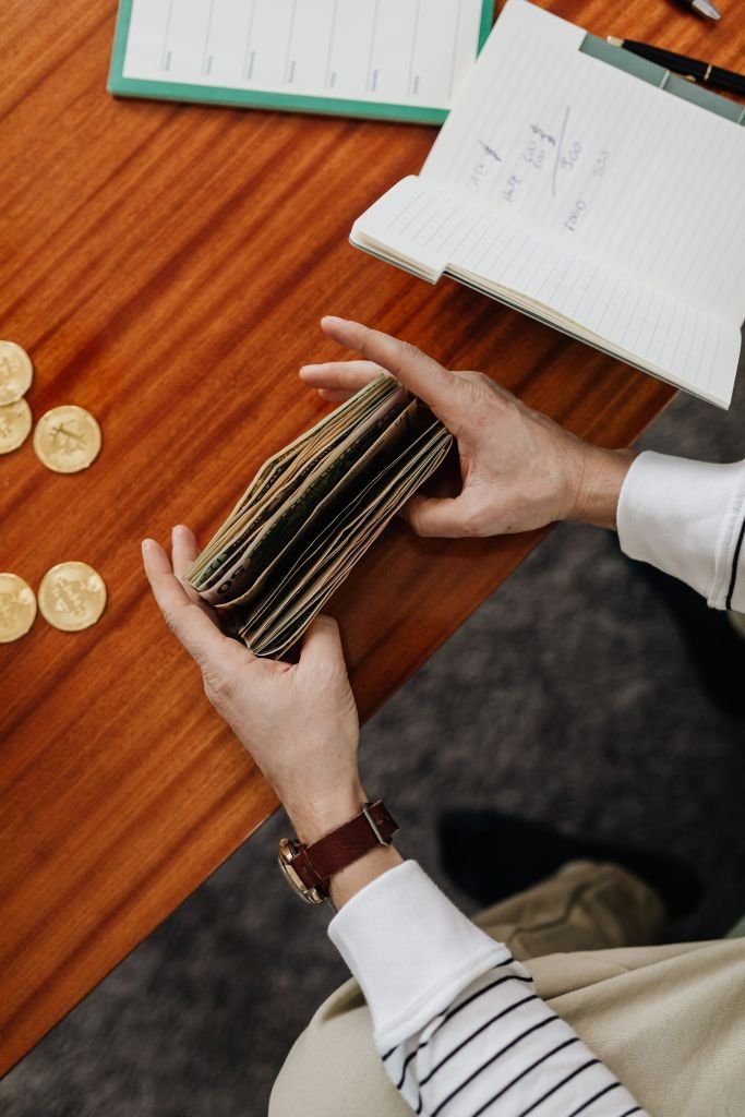 An empty wallet with a few coins on a table