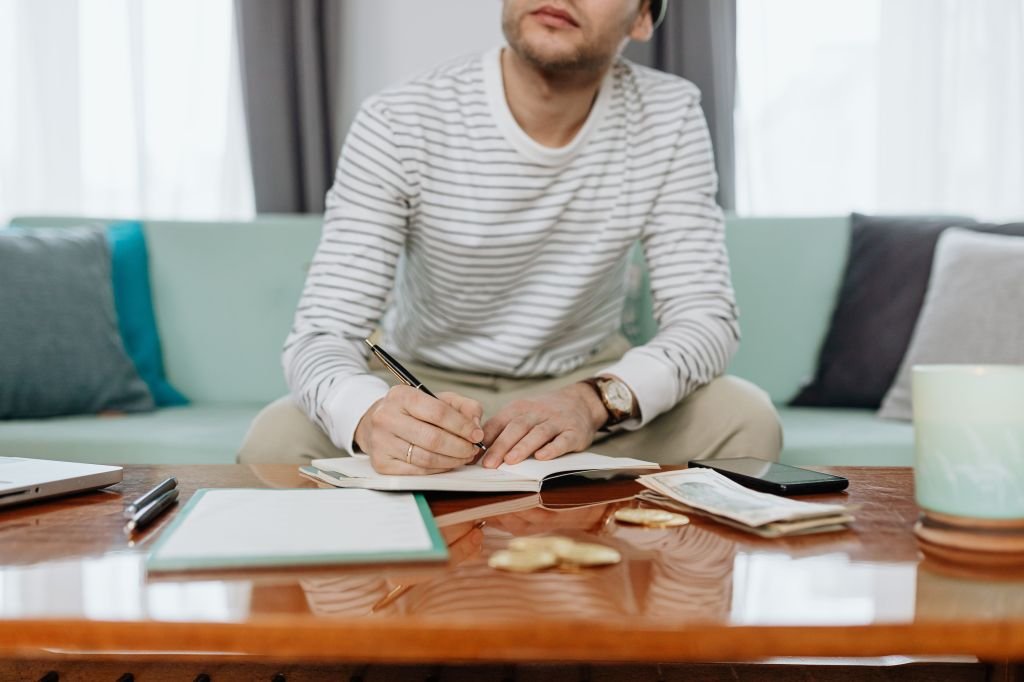 Person sitting calmly at desk planning and strategizing their side hustle income with notebook and pen