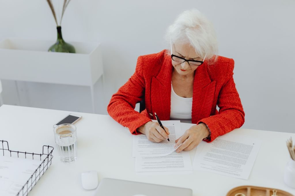 Older adult reviewing paperwork and documents at a table