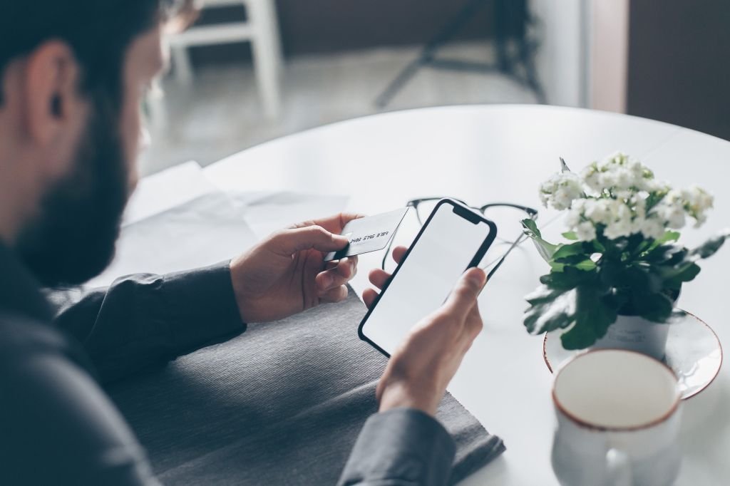 Person looking at phone checking bank account balance with concern and worry