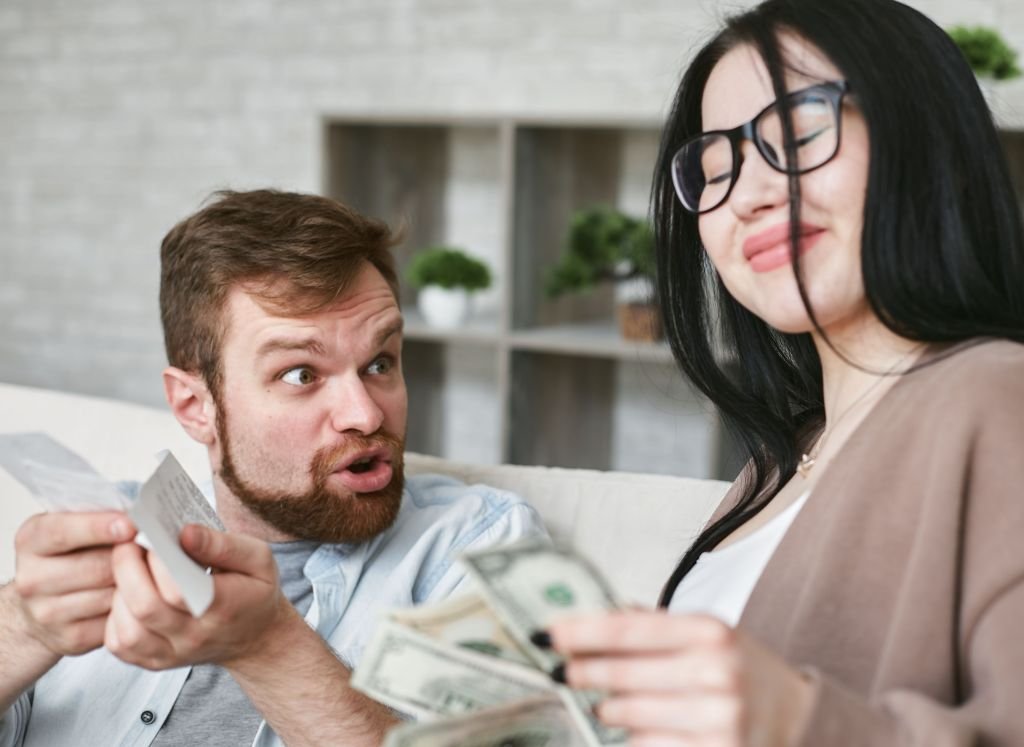 Parent reviewing a shopping receipt, looking concerned about rising prices