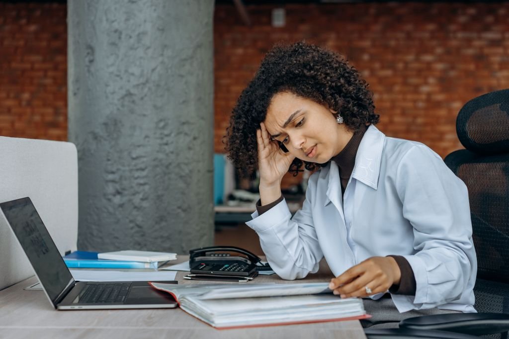 Person reviewing loan documents and calculator with concerned expression