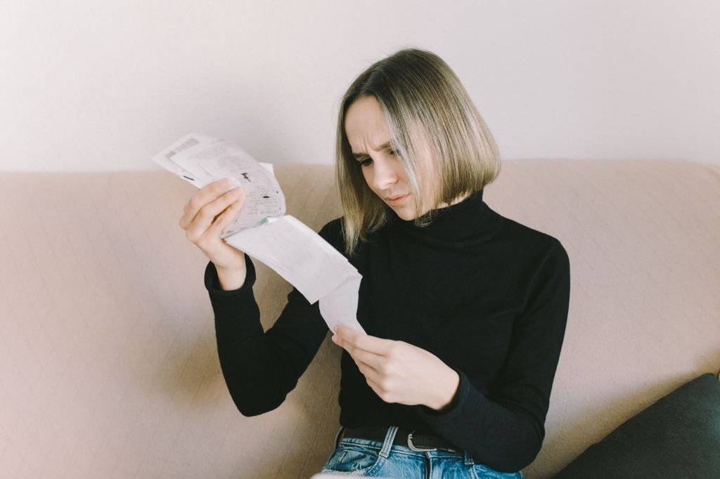 Person reviewing financial spreadsheet or payment calendar with concerned expression