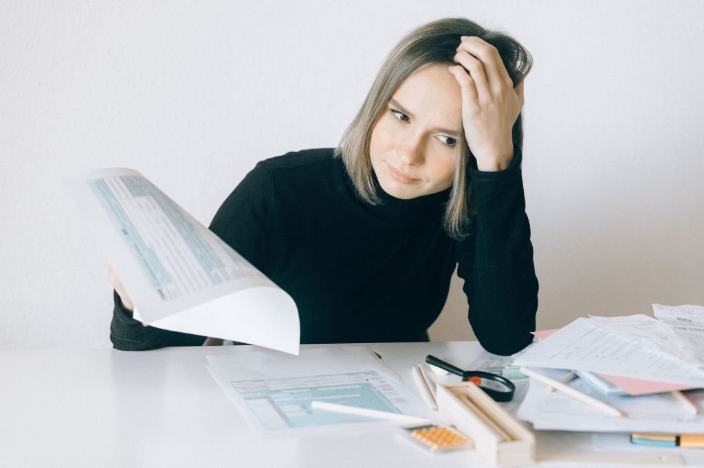 Person using a calculator while reviewing bills at a desk