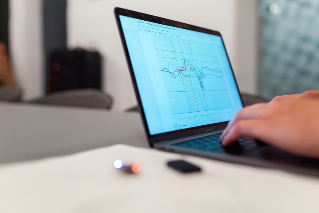Person researching on laptop analyzing investment information and data