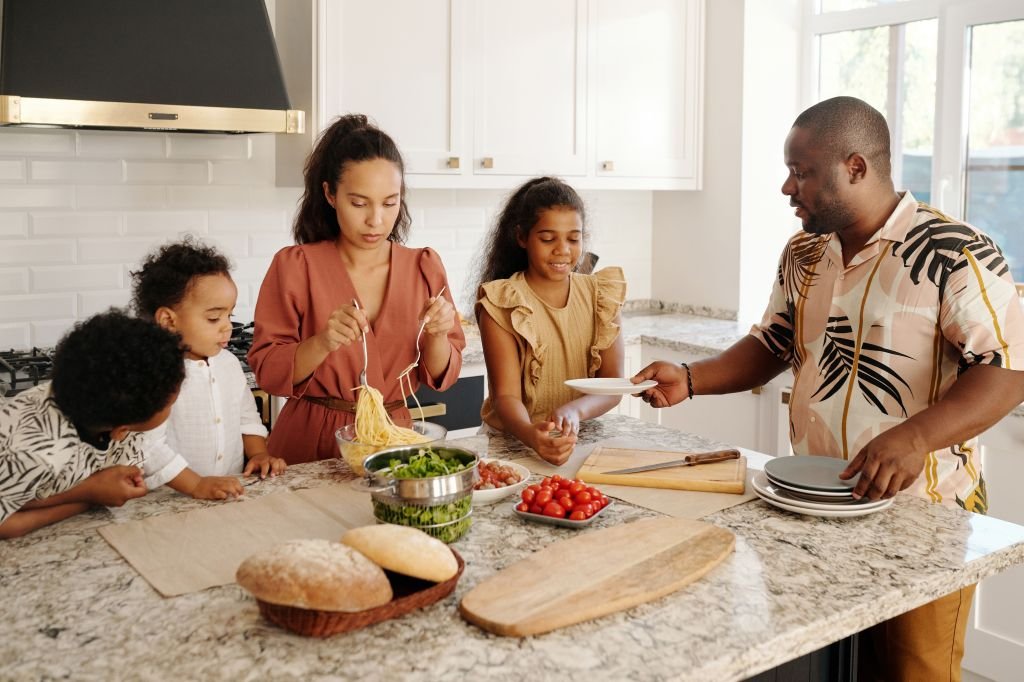 A person planning family meals in the kitchen to save on grocery costs